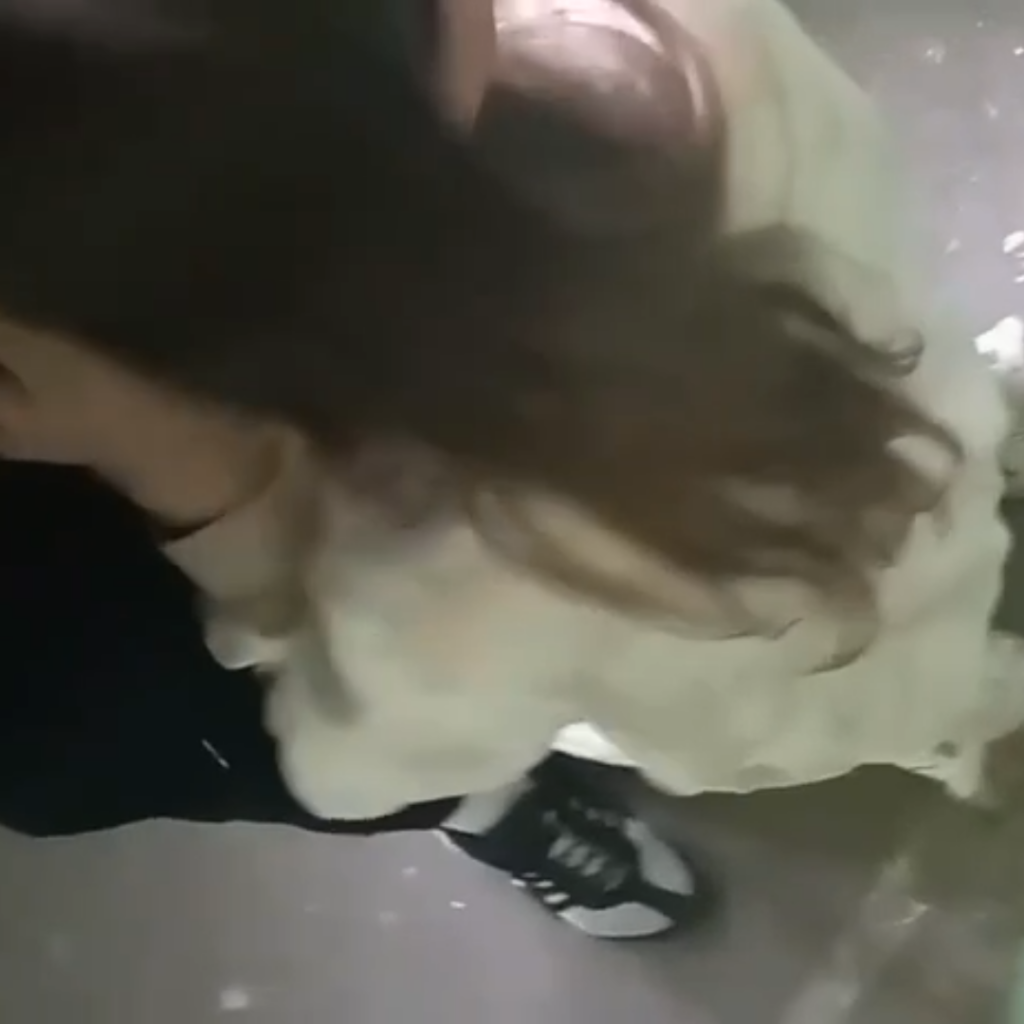 beautiful brunette sucking off a man's cock at a stairwell